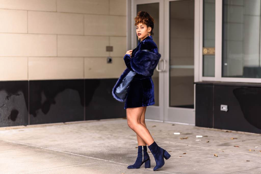 Woman in a blue monochromatic outfit with silk blouse and navy trousers.