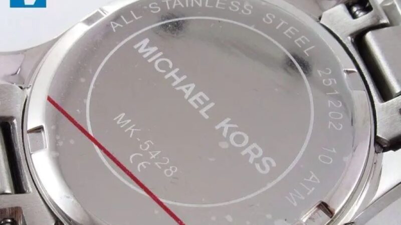 Close-up view of Michael Kors watch caseback showing engraved serial number for authenticity verification