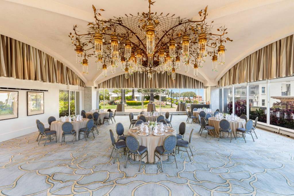 Historic Fairmont San Francisco grand ballroom set up for luxury fashion show with elegant seating and lighting