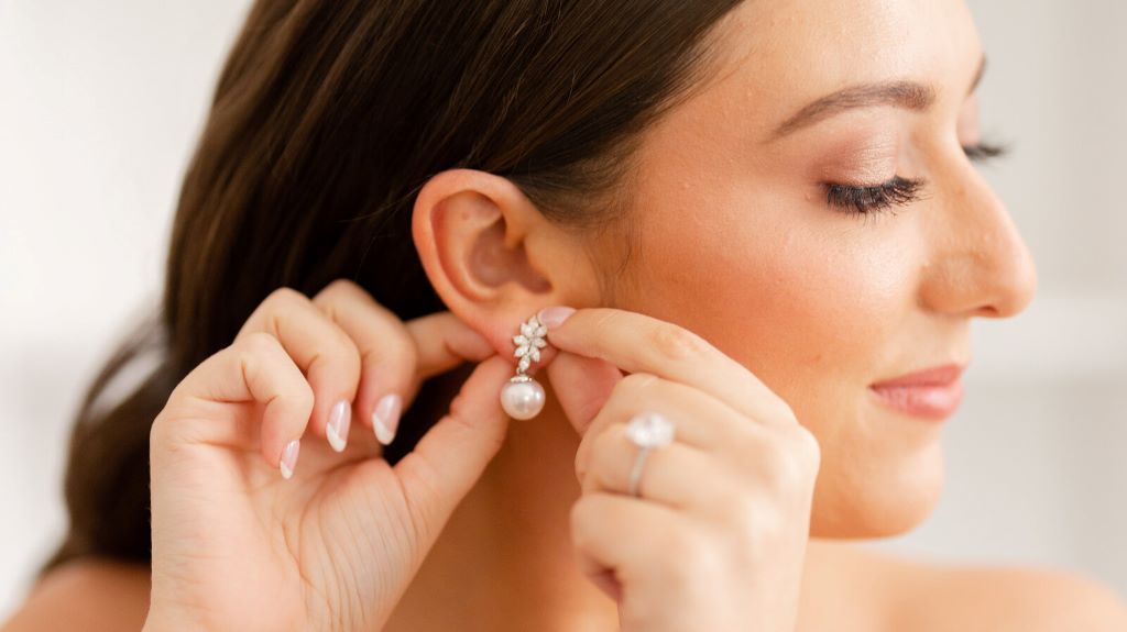 Close-up of pearl earrings paired with a bridal hairstyle and wedding gown