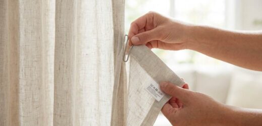 Woman vacuuming living room curtains with upholstery attachment